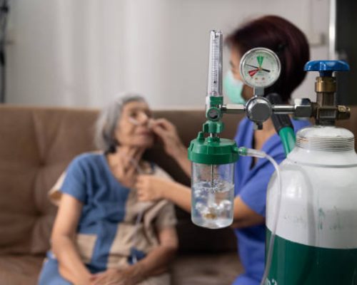 Elderly woman wearing oxygen nasal canula at home. Elderly woman wearing oxygen nasal canula at home.